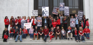 Activists on steps with signs