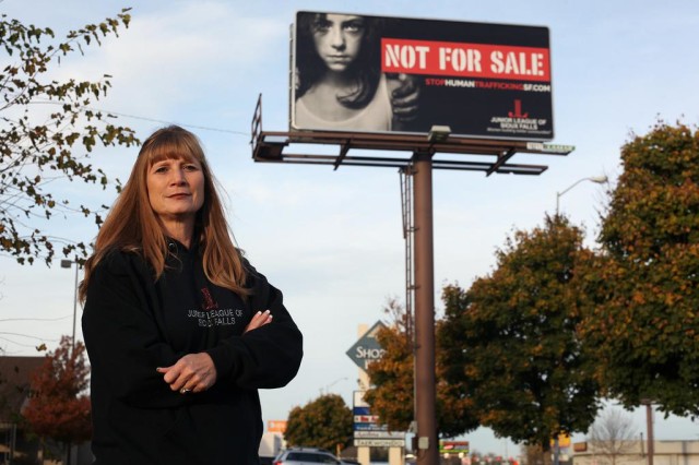 In this Oct. 27, 2015 photo, Dawn Stenberg, from the Junior League of Sioux Falls, stands near the group's anti-human trafficking billboard in Sioux Falls, S.D. While sex trafficking exists across the nation and is no more widespread here, there is something distinctive about South Dakota: About half the women in the federal cases have been Native American, a particularly vulnerable population in this state where some of the nations most impoverished communities are on reservations. (AP Photo/Jay Pickthorn)