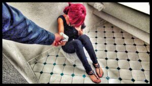 Girl sitting in bathroom being handed money