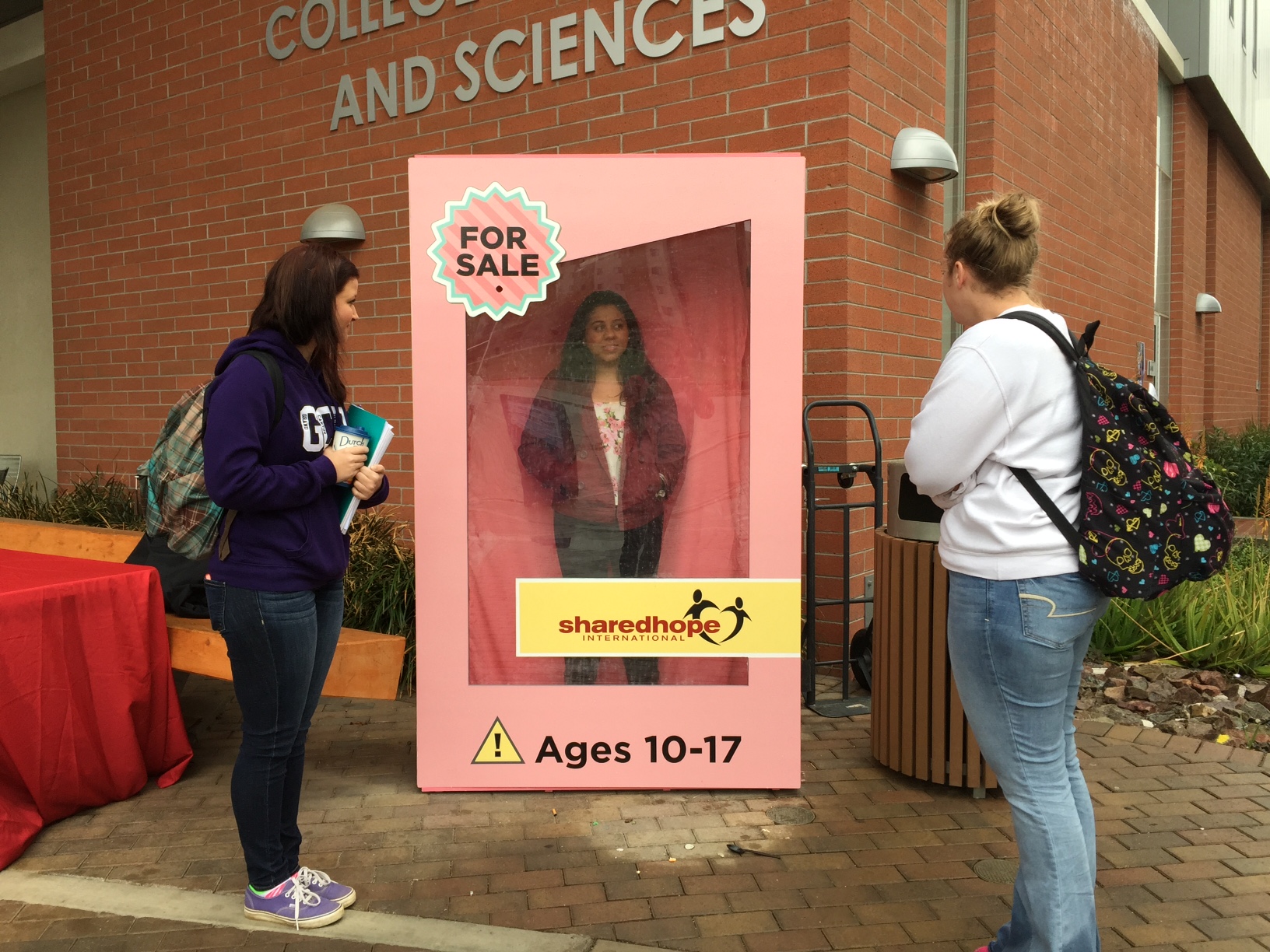 Students at Grand Canyon University view the doll box installation on campus.